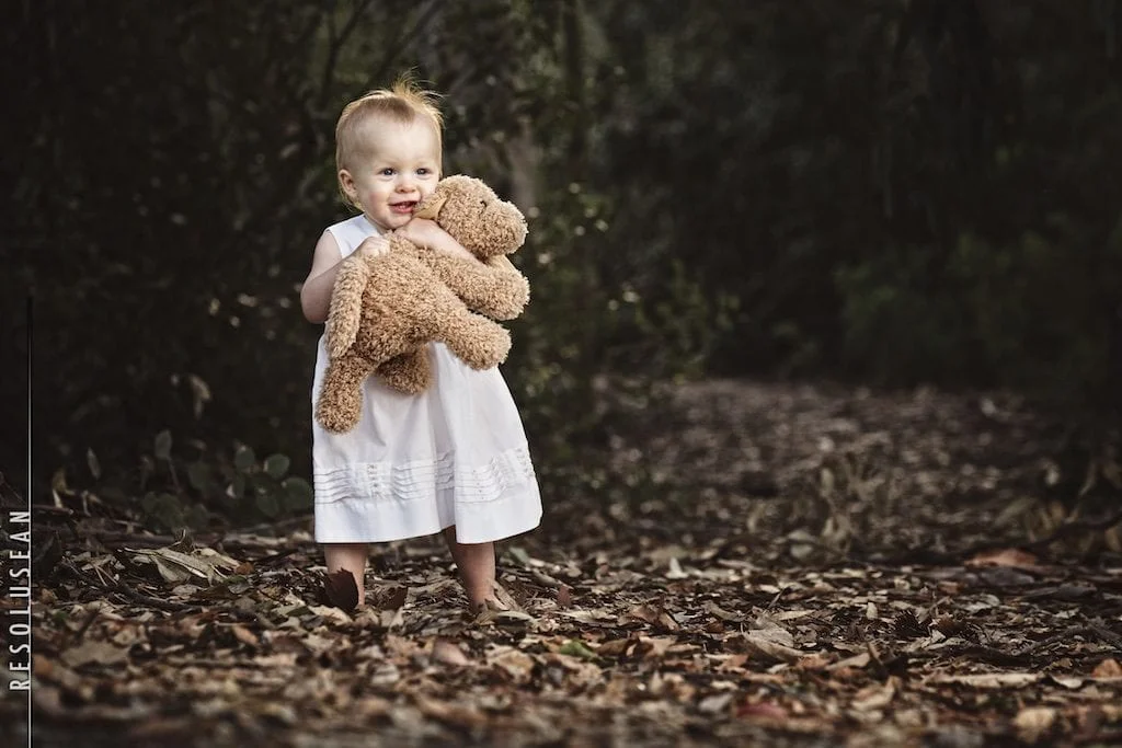 baby holding stuffed bear
