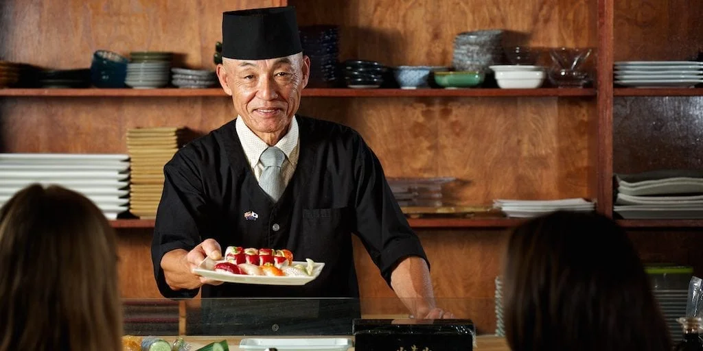 photo of sushi chef serving plate