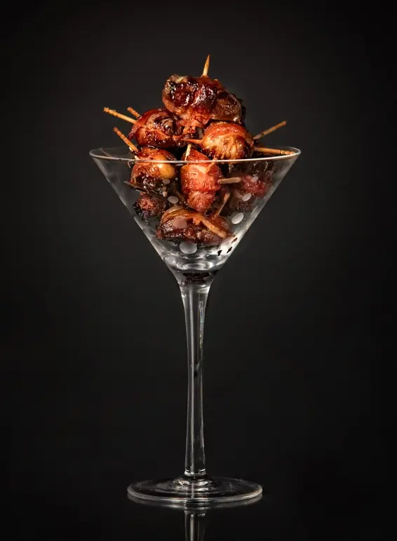 Appetizer in martini glass on black background