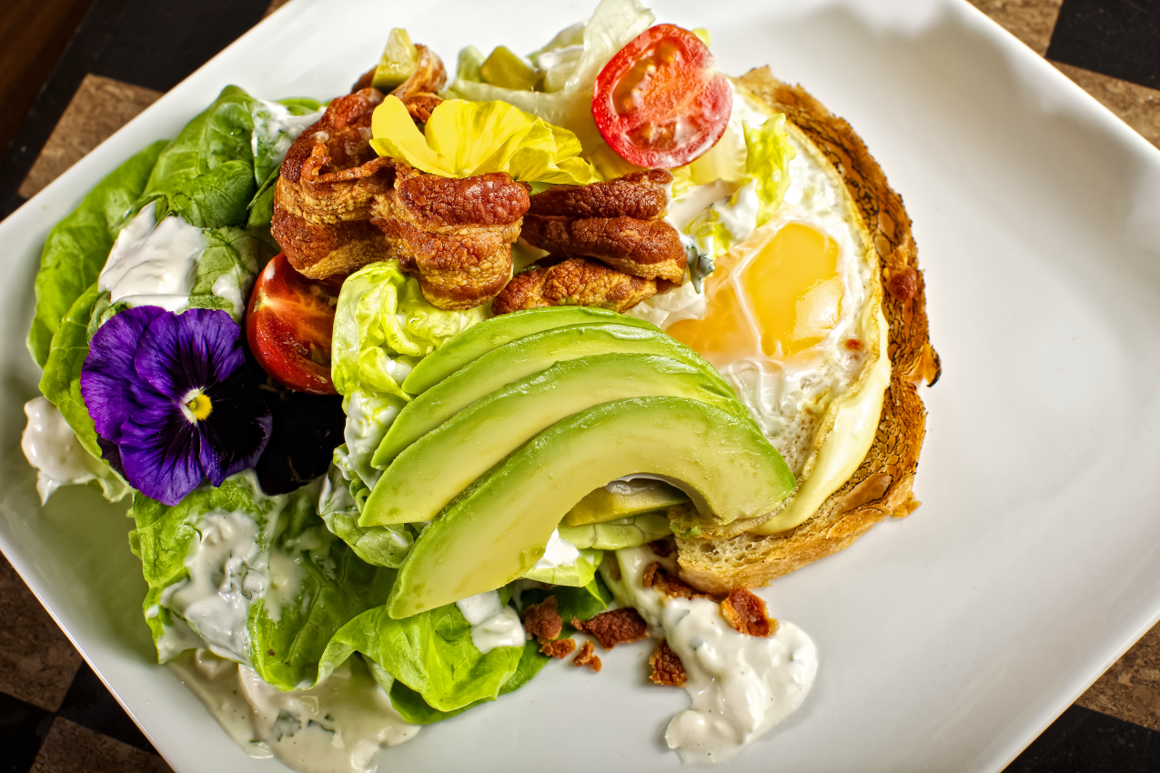 open face bacon ,egg, and avocado with mixed greens and dressing on toasted house made bread, food photography