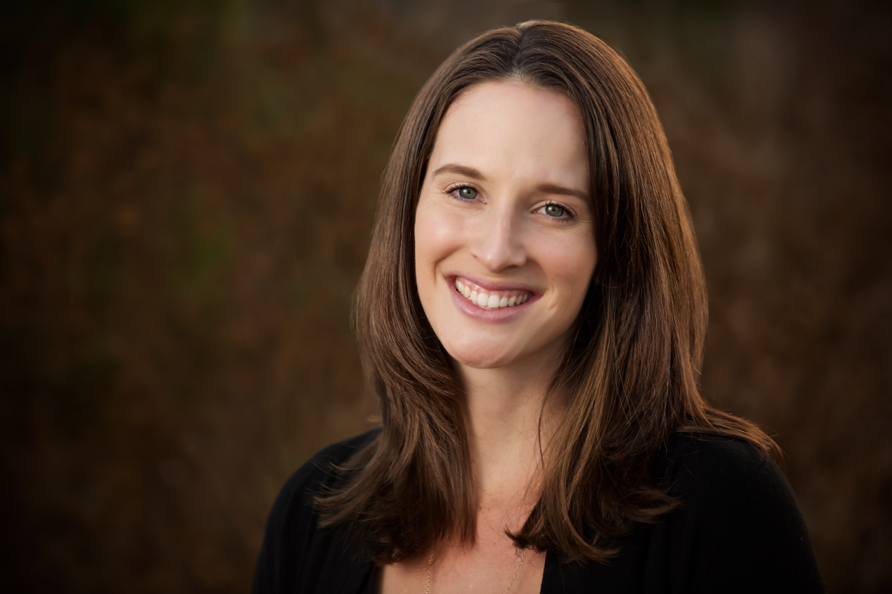 Professional head shot of a woman in a field of earth tones