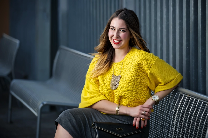 woman in yellow top sitting on bench outside Petco park San Diego
