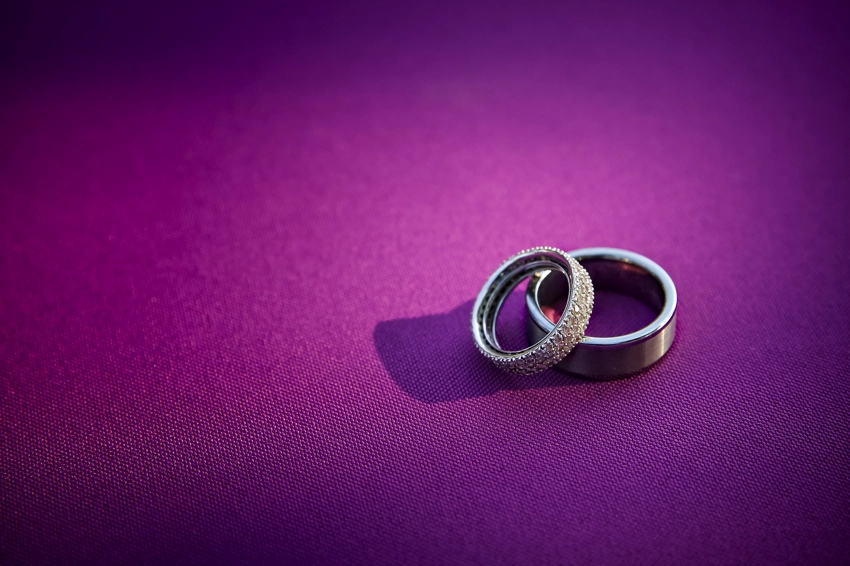 sliver wedding rings stacked on purple